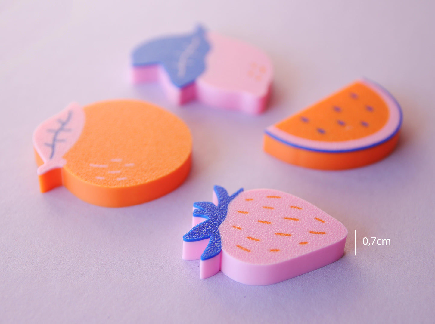 colorful 3D-printed magnets in the shape of fruit: orange, strawberry, lemon and melon