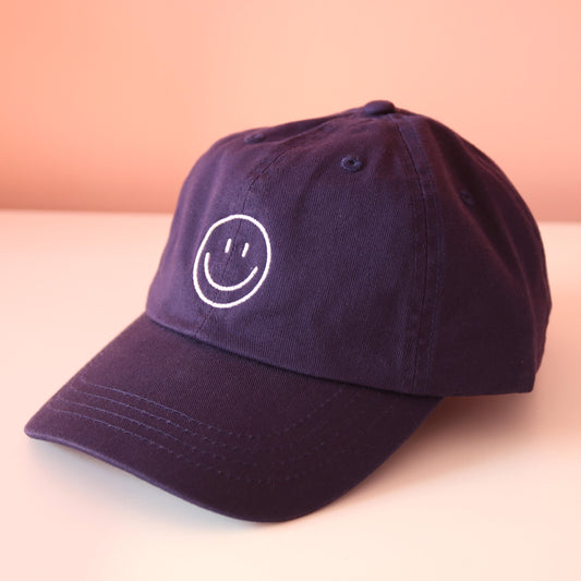 Seitenansicht navy Cap mit aufgesticktem weißem Smiley