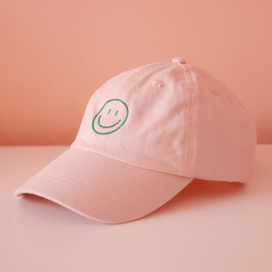Seitenansicht rosa Cap mit aufgesticktem grünem Smiley