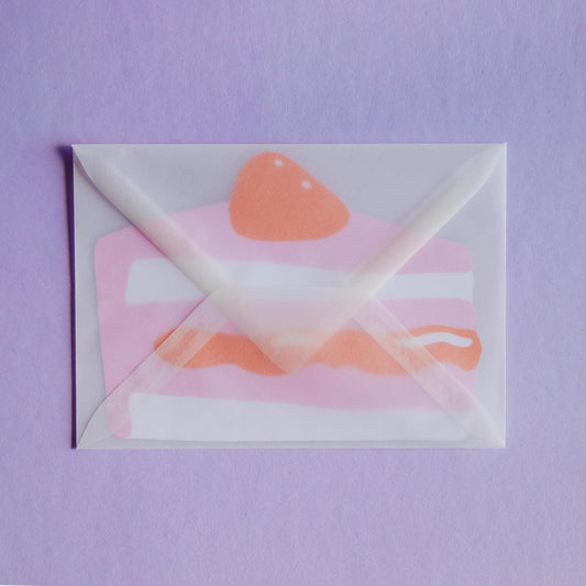 a postcard shaped like a piece of cake inside a transparent envelope