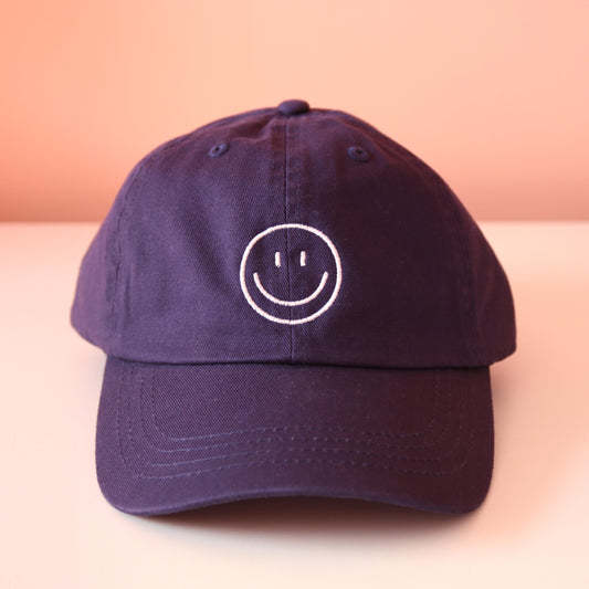 Frontansicht navy Cap mit aufgesticktem weißem Smiley