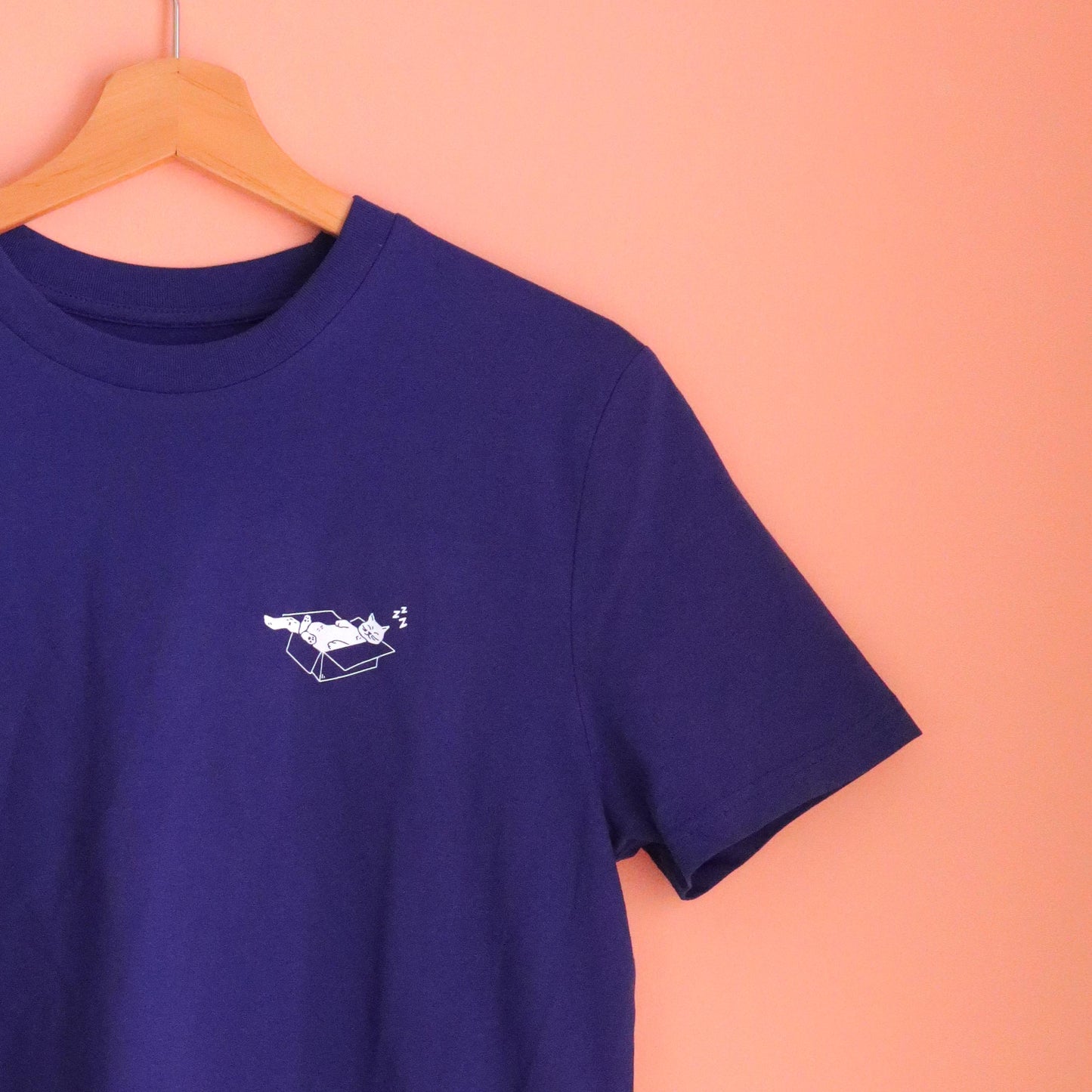 blaues unisex T-Shirt mit einer weißen Siebdruck Illustration einer Katze, die in einem Karton schläft