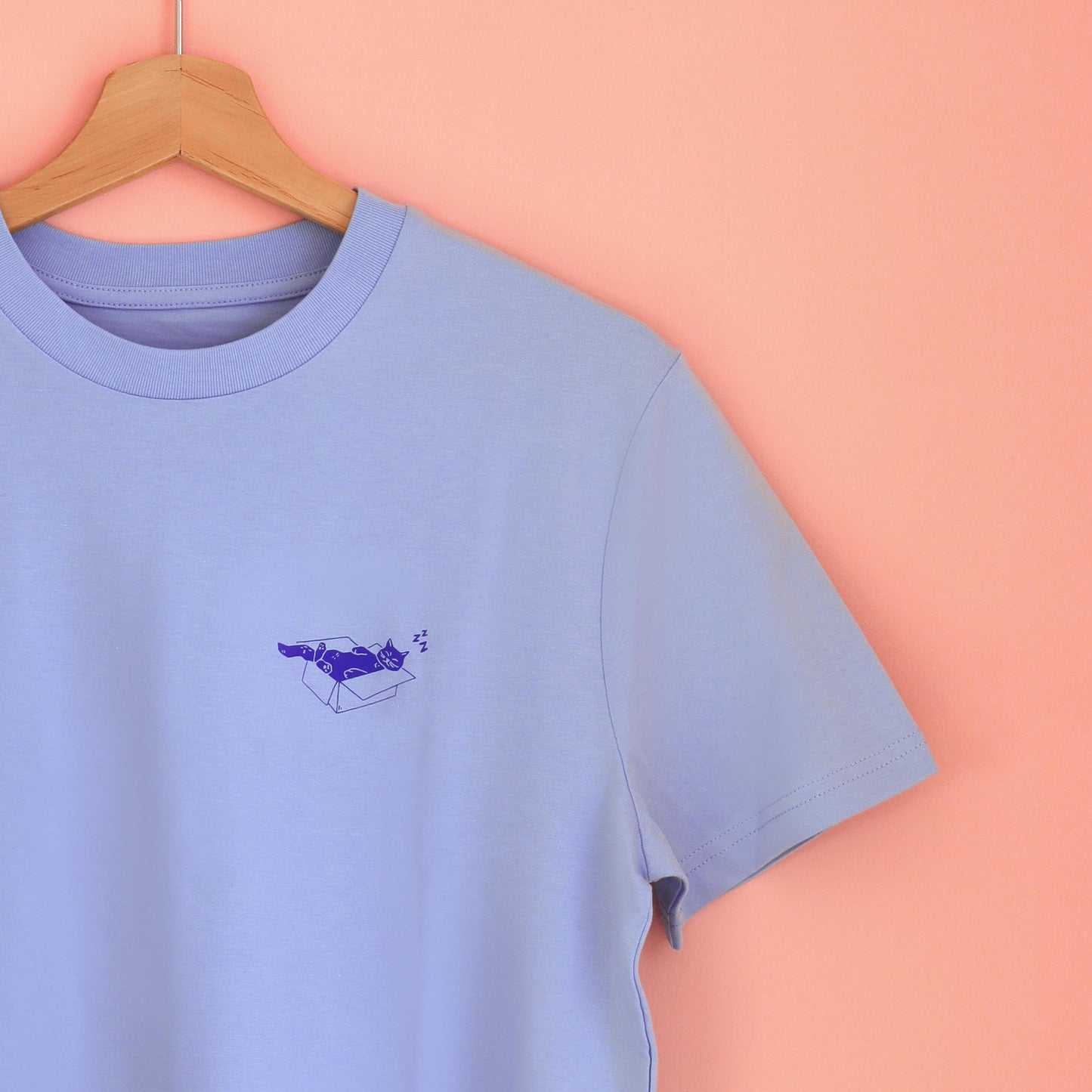 hellblaues unisex T-Shirt mit einer blauen Siebdruck Illustration einer Katze, die in einem Karton schläft