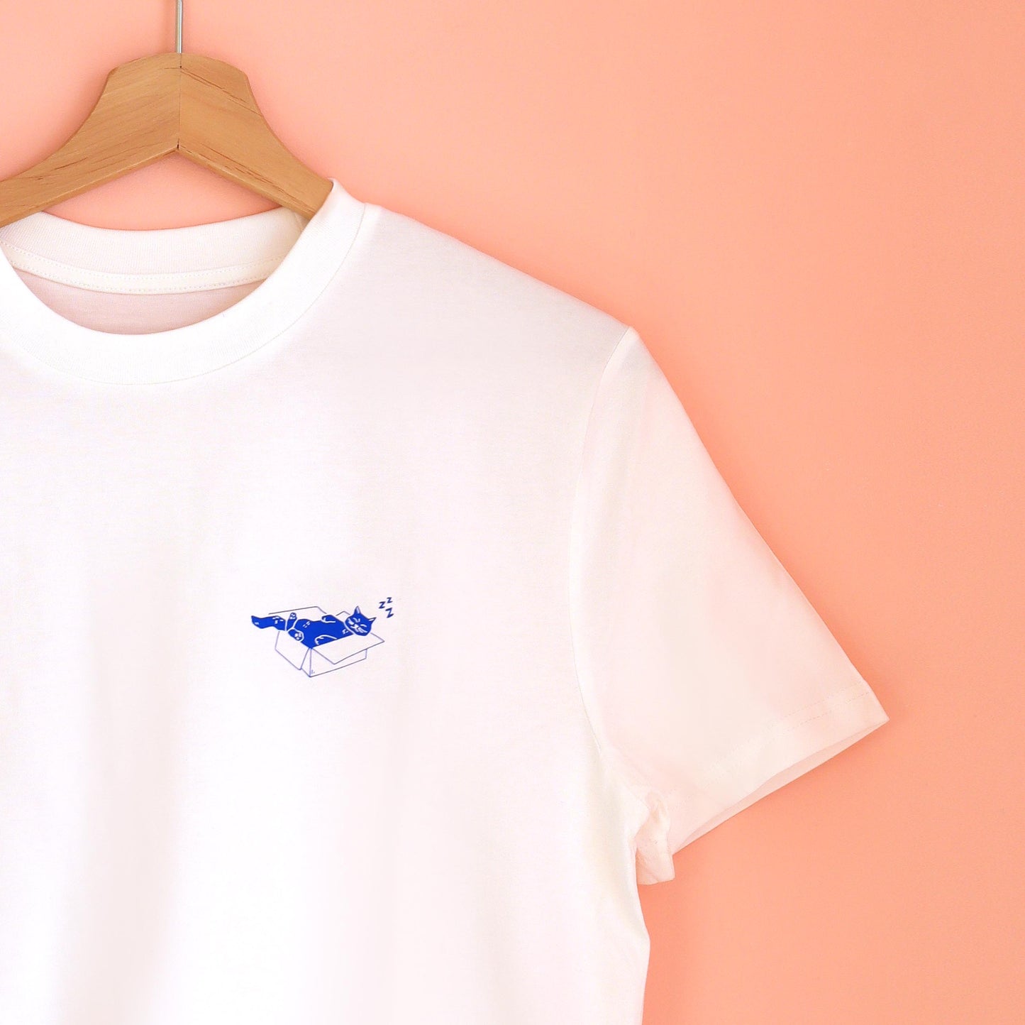 weißes unisex T-Shirt mit einer blauen Siebdruck Illustration einer Katze, die in einem Karton schläft