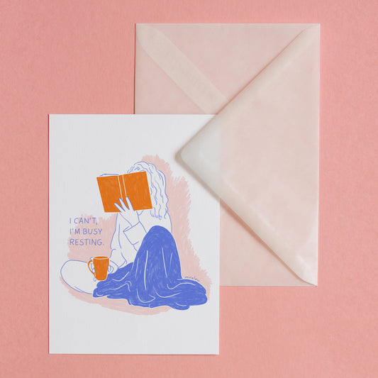 Postkarte mit Illustration einer Person mit Buch und Teetasse in der Hand mit dem Spruch "I Can't I'm Busy Resting" in blau und orange